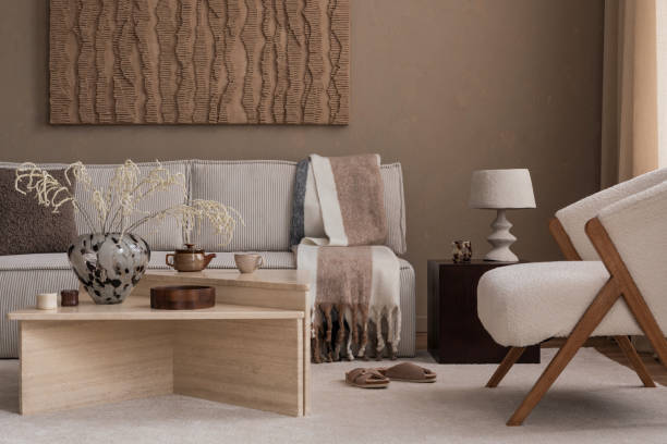 Warm and cozy autumn composition of living room interior with mock up poster frame, art, boucle sofa, stylish coffee table, patterned rug, marble lamp and personal accessories. Home decor. Template.